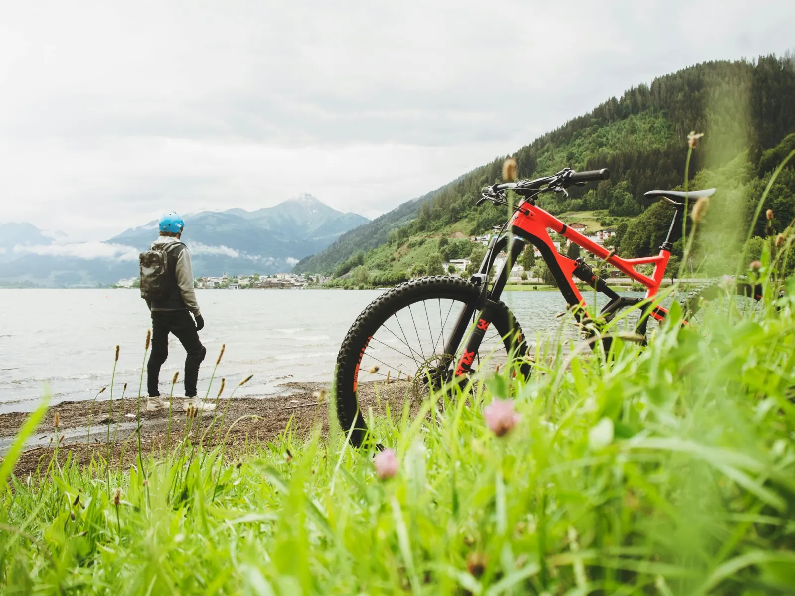 A mountain bike beside a lake with mountains in the distance